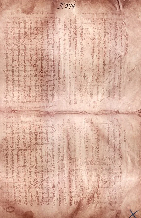 A worn parchment page with faint older writing running underneath a later text written across it.